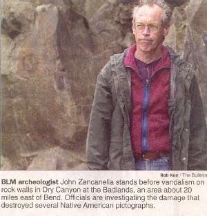 BLM archiologist stands before damaged pictographs